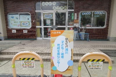 入り口前に花の植木鉢がある外観写真