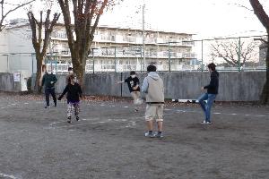 外で高校生たちがサッカーをしている写真