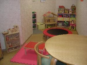 机やトランポリンが設置されている子ども家庭支援センターの室内の写真