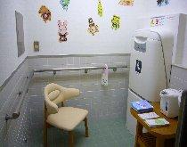 壁に手すりが備え付けてあり、椅子1脚、ポット、おむつ交換台がある南大沢保健福祉センターに新しくつくられた赤ちゃん・ふらっとの写真