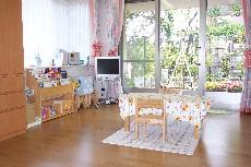 部屋の中央にテーブルクロスのかかったテーブルがあり、窓から明かりが入っているからまつキッズウイングルームの写真