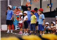 赤い帽子を被った子供2人と白い帽子を被った子供2人がスタートラインに立っている運動会の写真