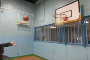 遊戯室にあるバスケットボールのゴールに向かってボールを投げている写真