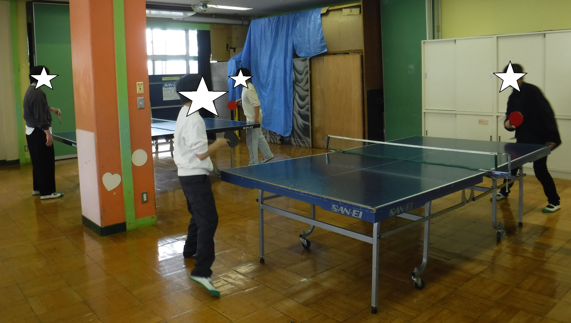 遊戯室で中学生が卓球をする様子