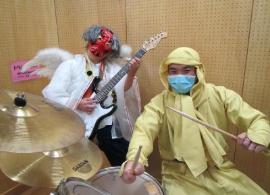 ドラム用のスティックを持った黄色い忍者とギターを持った天狗が児童館内で撮影された写真