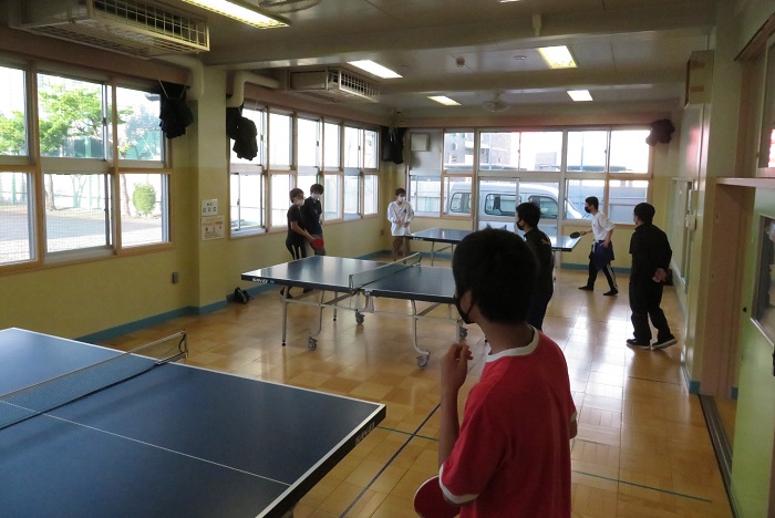 遊戯室で卓球をする中学生の写真
