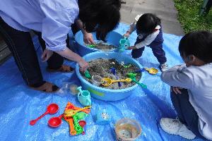 乳幼児活動で砂遊びをする乳幼児の様子